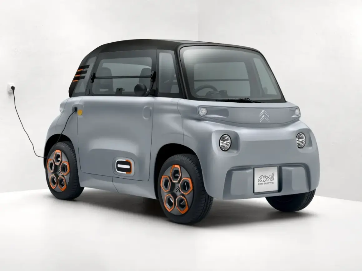 Szary Citroen Ami podłączony do ładowania. Ten elektryczny pojazd miejski oferuje praktyczny zasięg na co dzień.