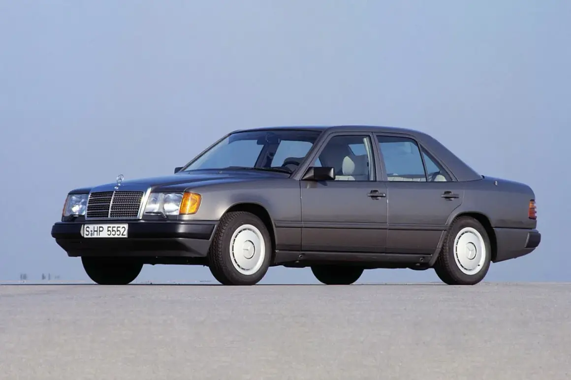 Szary Mercedes W124, symbol najbardziej niezawodnych samochodów, stoi na płaskiej nawierzchni.