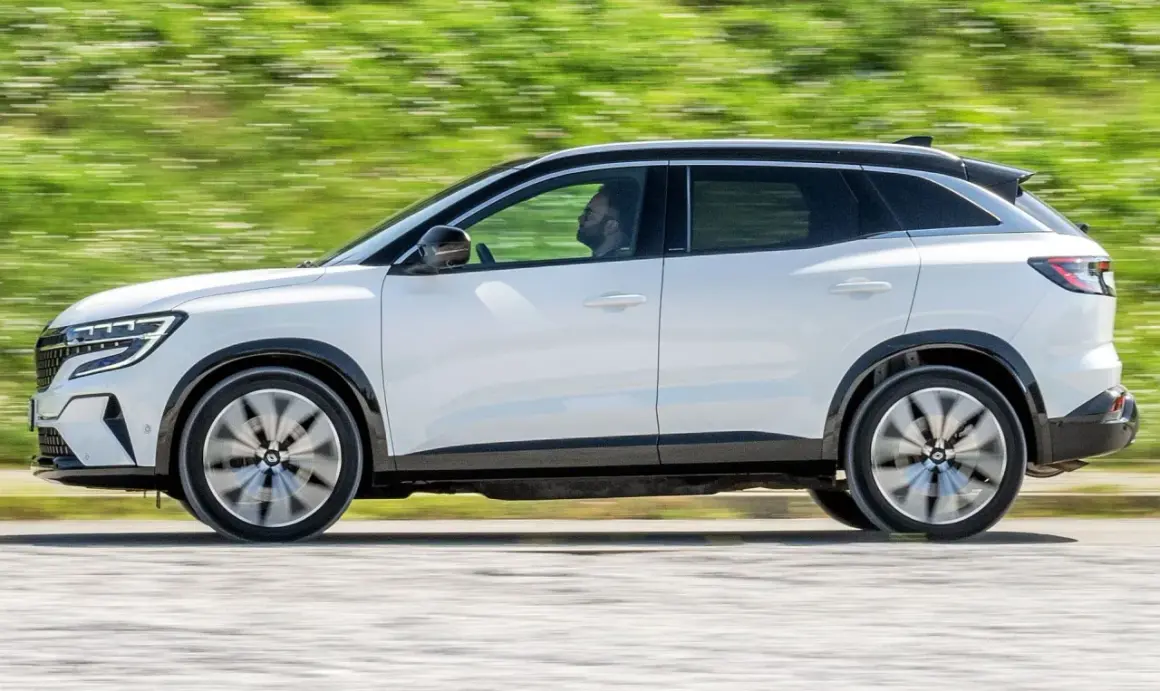 Biały Renault Austral w ruchu, z widocznym kierowcą. Jego dynamiczna sylwetka i nowoczesne linie podkreślają jego wymiary.