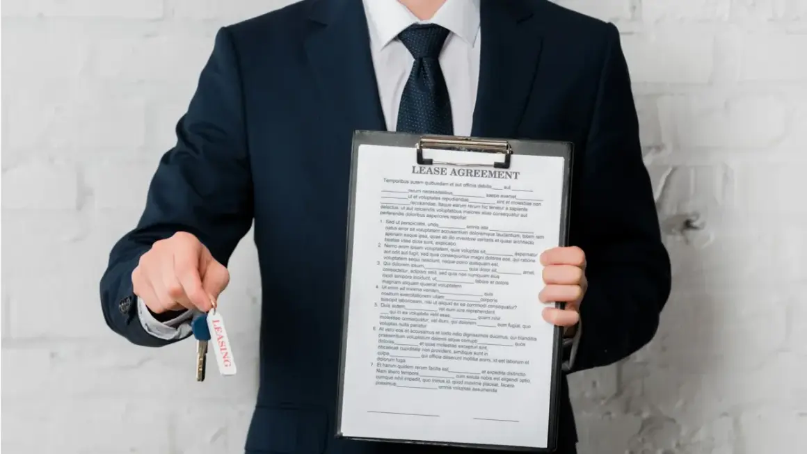 Biznesmen z umową leasingową i kluczami. Sprawdź, jak sprawdzić czy dostanę leasing, aby zacząć swoją drogę do posiadania wymarzonego pojazdu.