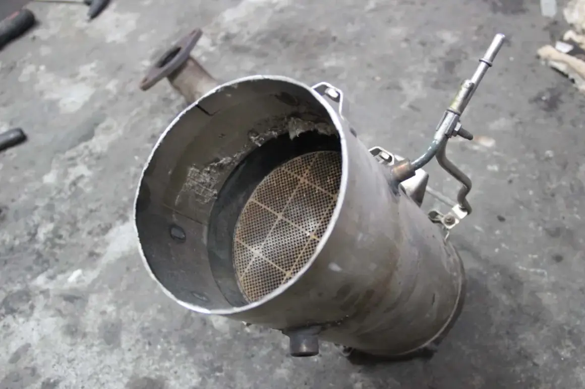 Filtr cząstek stałych, czyli DPF, z widocznym w środku ceramicznym wkładem o strukturze plastra miodu.