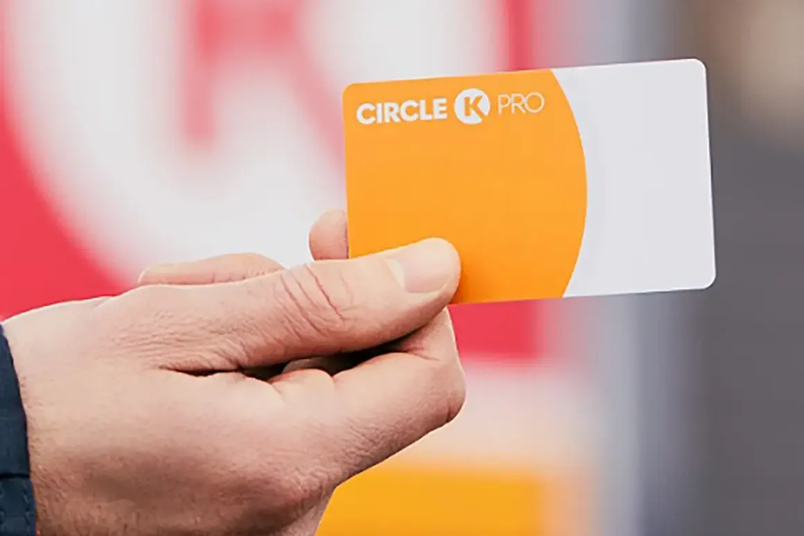Dłoń trzyma pomarańczowo-białą kartę flotową Circle K PRO.