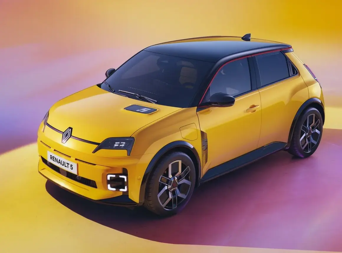 Żółty samochód elektryczny Renault 5 z czarnym dachem i czerwonym akcentem.