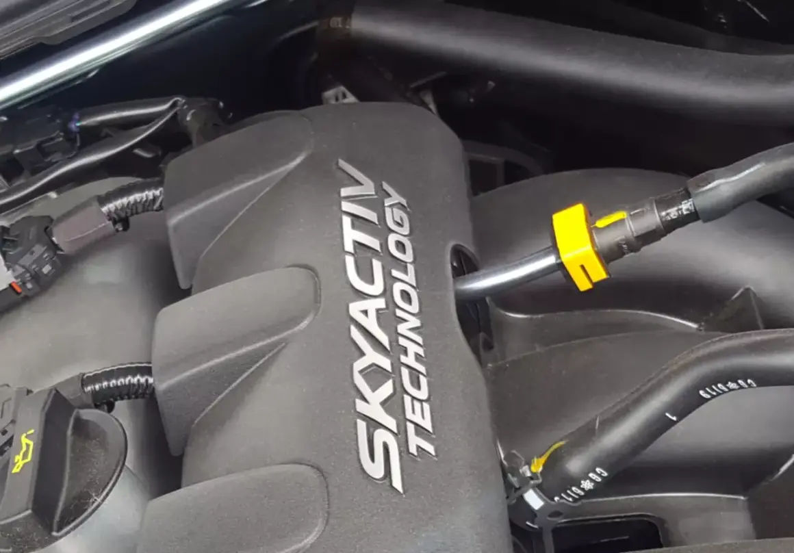 Silnik SKYACTIV TECHNOLOGY, serce oszczędnych silników benzynowych, z widocznymi przewodami i złączkami.