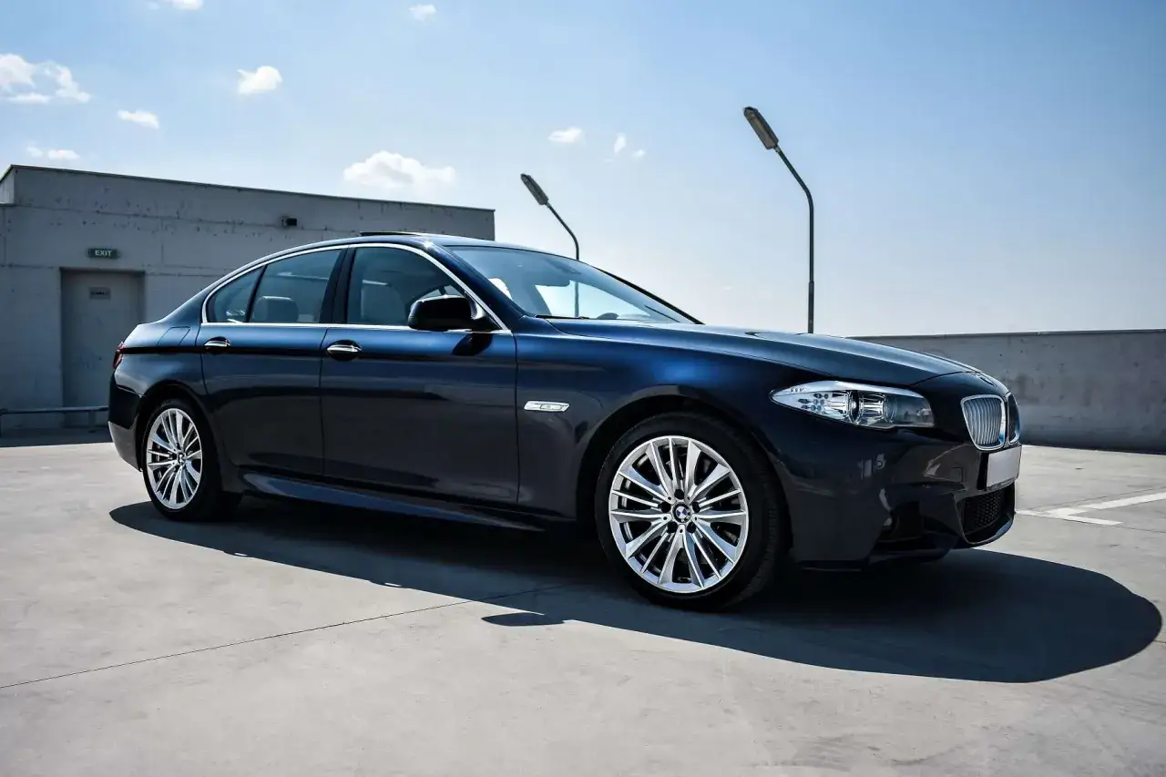 Ciemnoniebieskie BMW na parkingu. Idealny wybór dla firm ceniących sobie komfort i prestiż, dostępny w ramach leasingu operacyjnego.