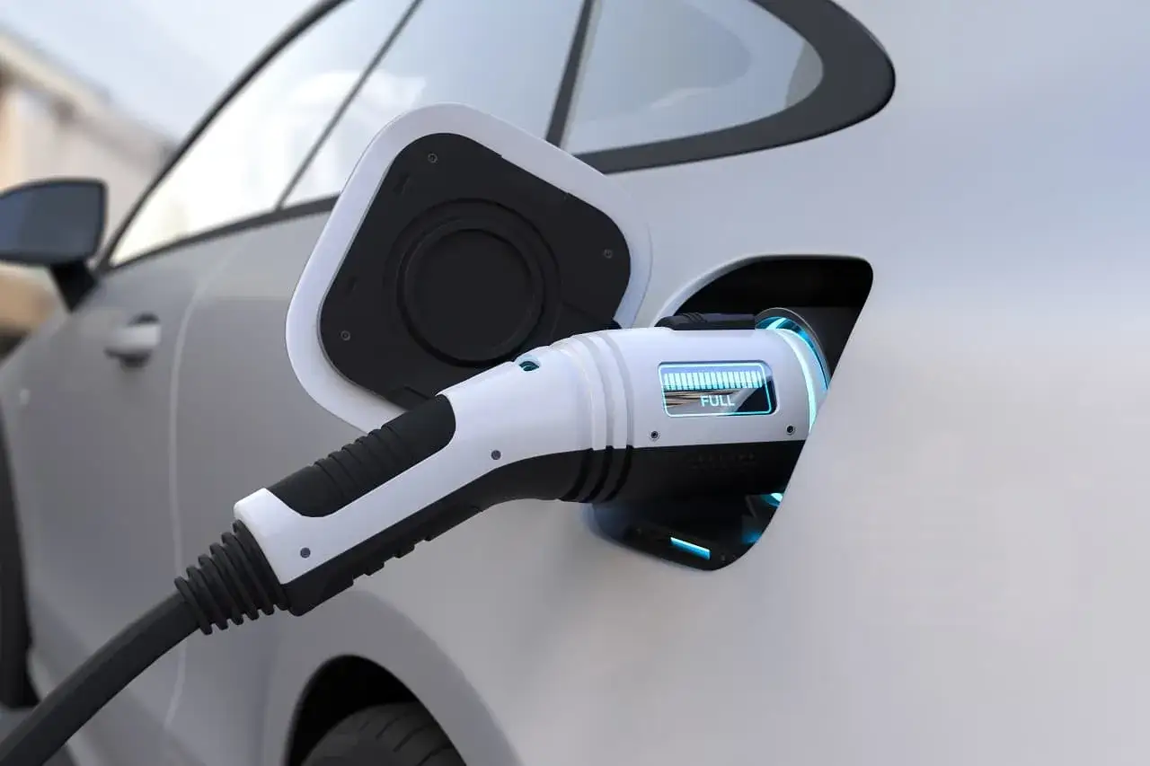 Ładowanie samochodu elektrycznego. Czy samochód elektryczny się opłaca? Wskaźnik pokazuje pełne naładowanie.