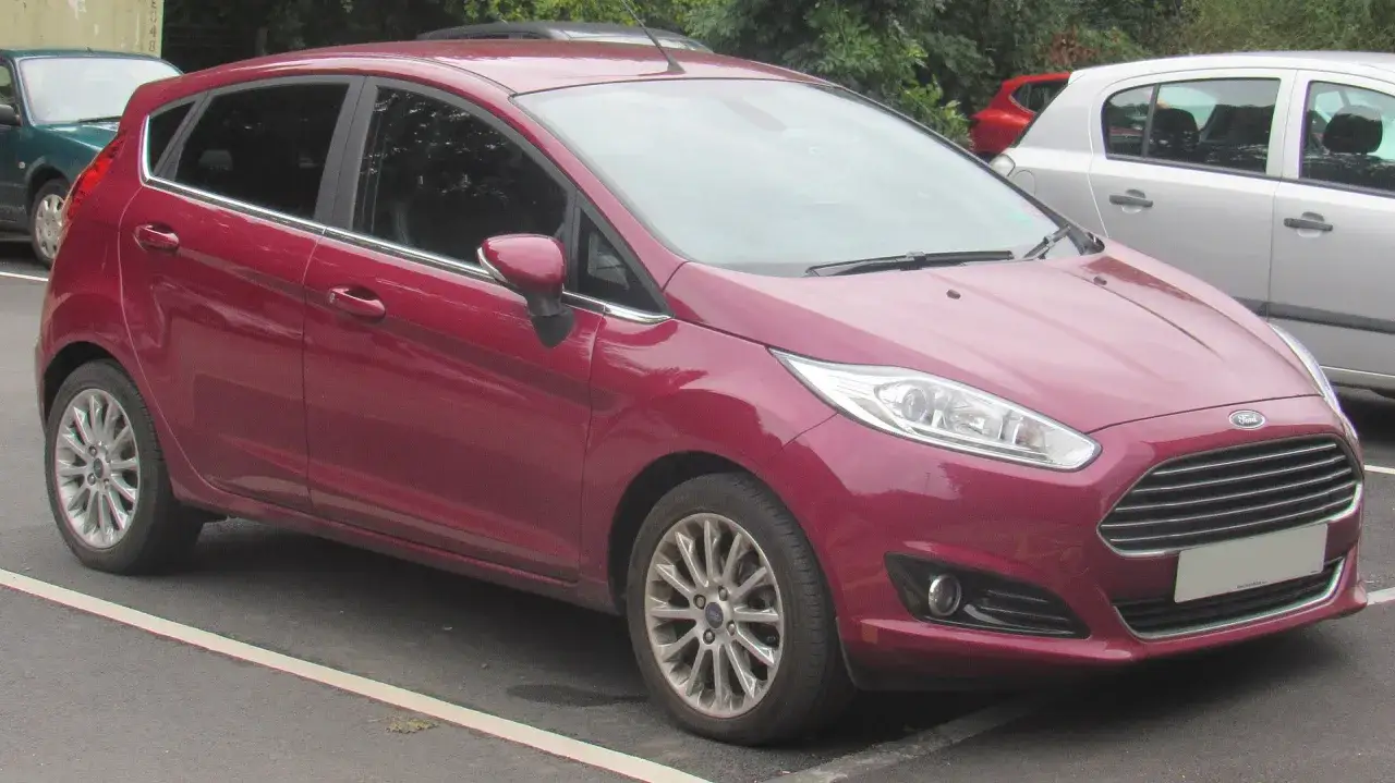 Czerwony Ford Fiesta, idealne pierwsze auto dla dziewczyny. Stylowy i praktyczny, gotowy na nowe przygody.