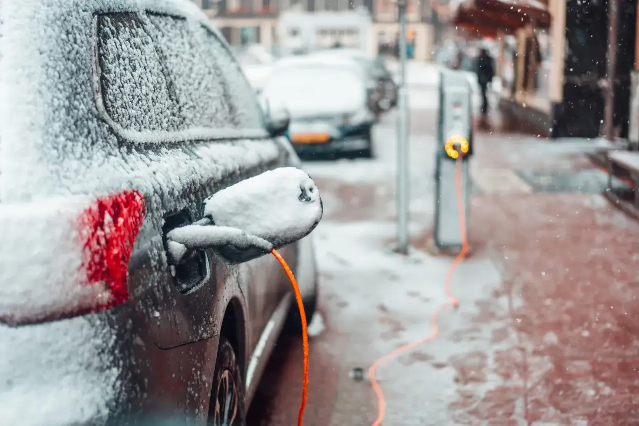 Samochód elektryczny ładowany na mrozie. Zima nie wpływa znacząco na to, ile prądu zużywa samochód elektryczny, ale może wydłużyć czas ładowania.