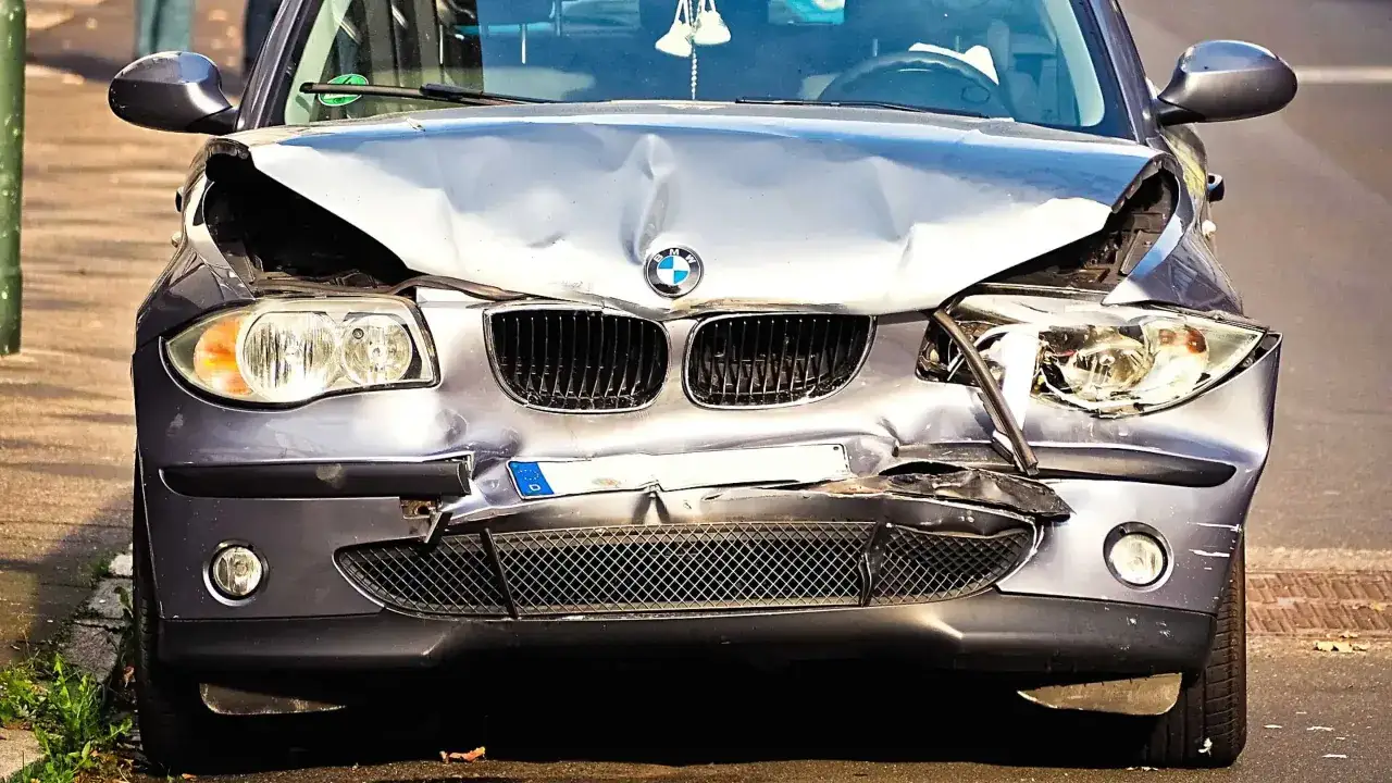 Uszkodzony BMW na parkingu. Zderzenie spowodowało szkody całkowite, co oznacza koniec leasingu.