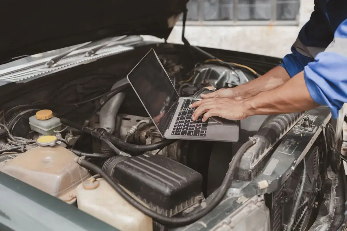 Mechanik diagnozuje brak mocy w aucie, używając laptopa do analizy danych silnika.
