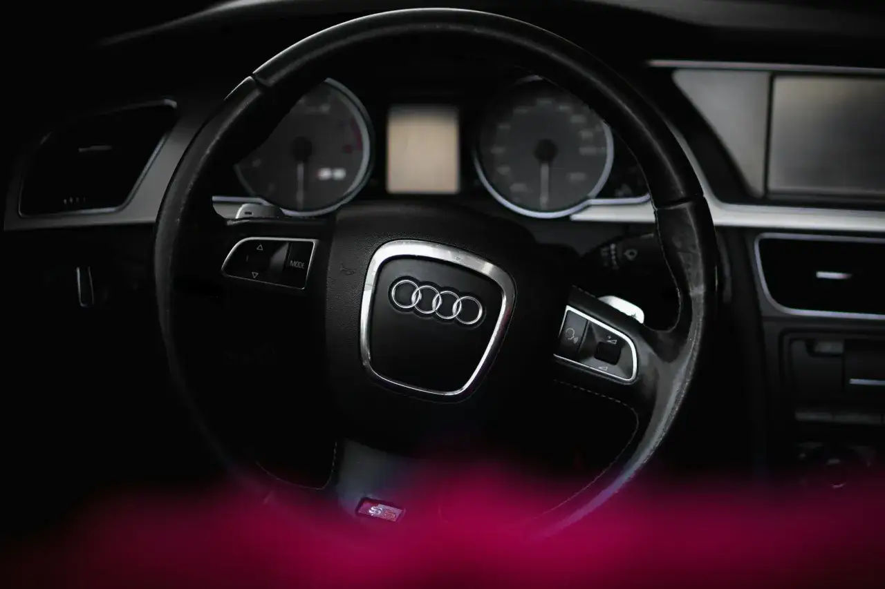 Wnętrze Audi S5, gotowe do sprowadzenia auta z Niemiec. Kierownica z logo i przyciskami, deska rozdzielcza.