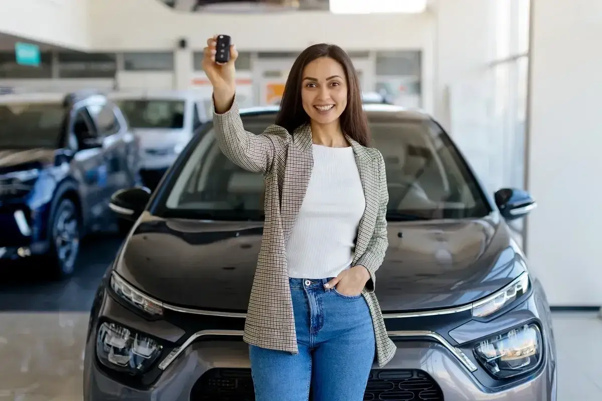 Kobieta z kluczykami do nowego auta, które właśnie kupiła. Chcesz wiedzieć, jak sprawdzić czy auto jest w leasingu?