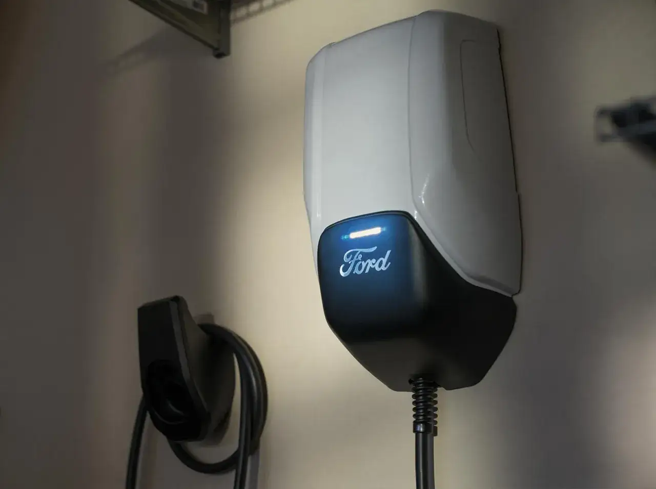 Stacja ładowania samochodu elektrycznego Ford z podświetlanym logo. Gotowa do ładowania.