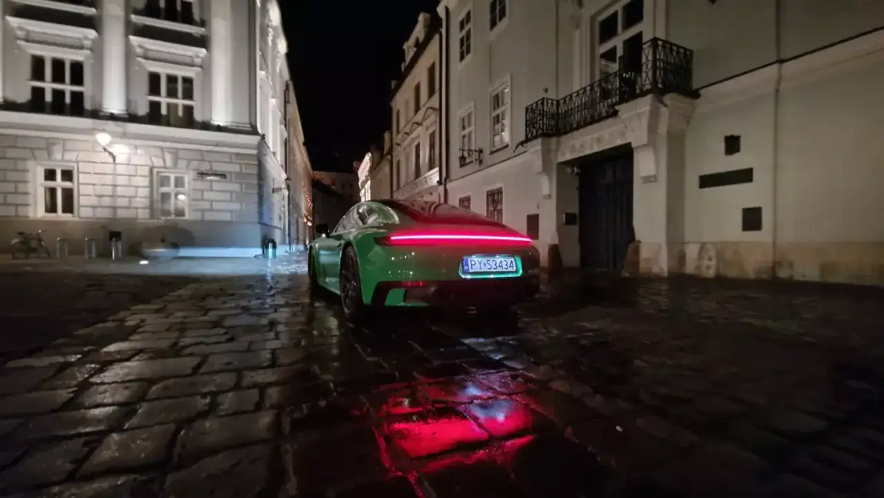 Zielone Porsche na mokrym bruku nocą. Czy to koniec leasingu, co dalej z tym pięknym autem?