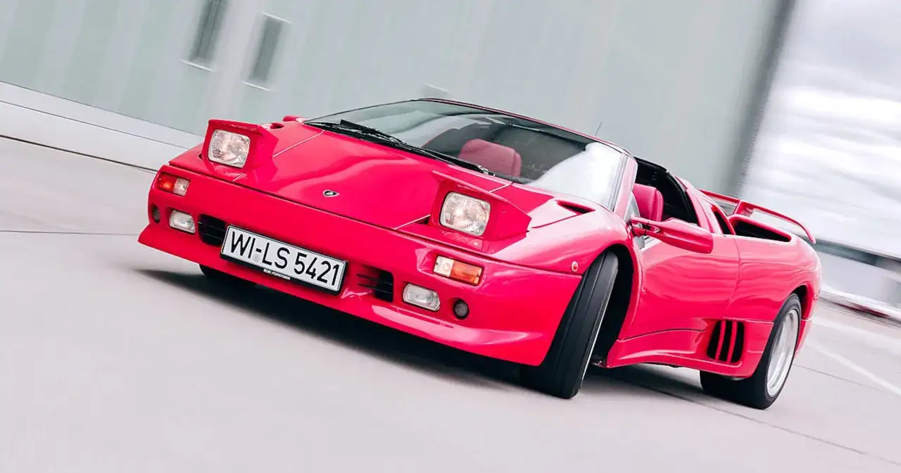 Czerwony Lamborghini Diablo, jeden z najbardziej niezawodnych samochodów, pędzi po drodze.