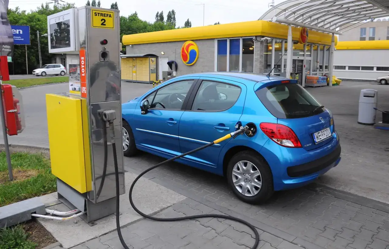 Niebieski Peugeot tankuje gaz LPG na stacji. To jeden z najlepszych aut do gazu, ekonomiczny wybór.