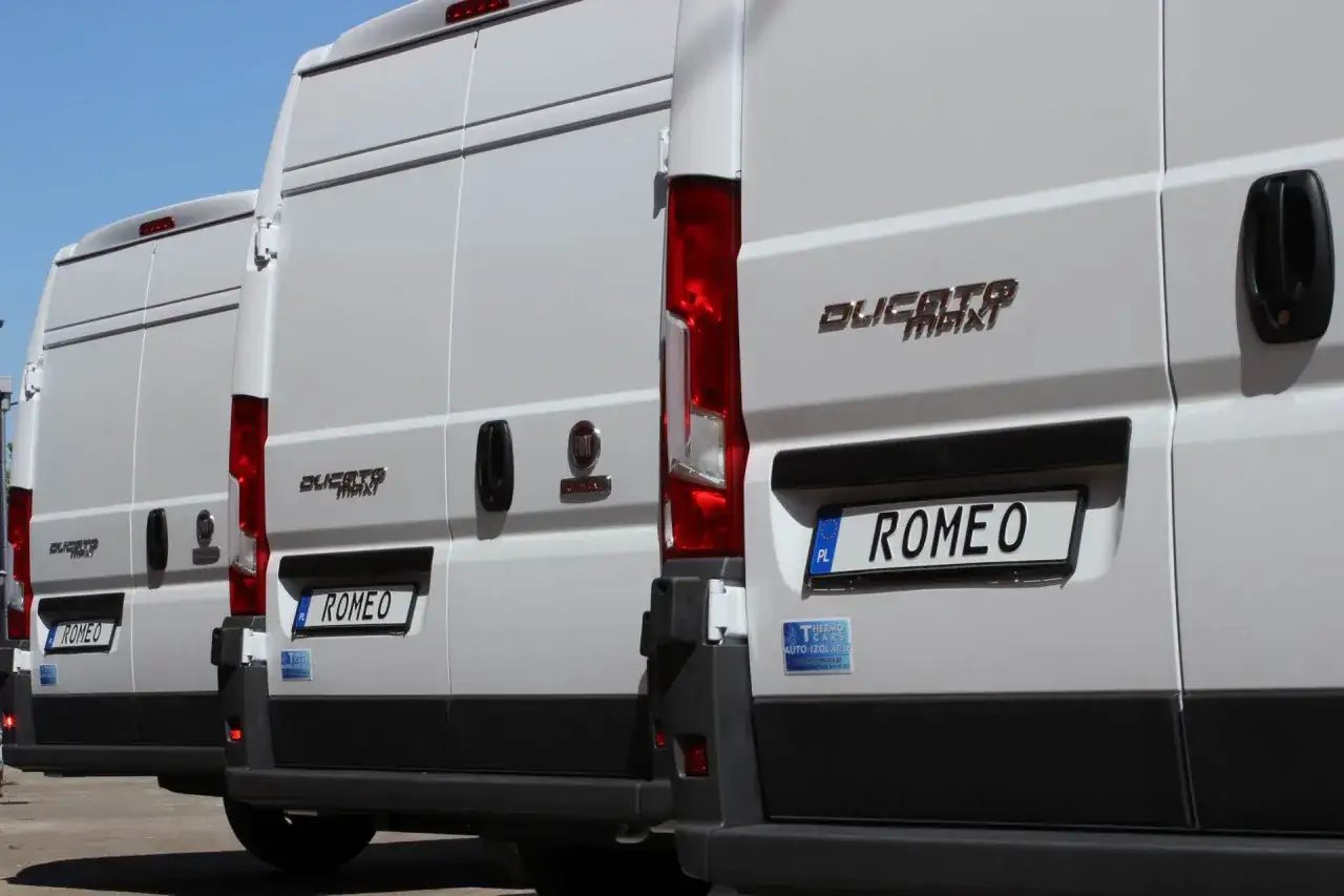 Rząd białych Fiatów Ducato Maxi, idealnych do transportu. Te najlepsze samochody dostawcze z napisem 