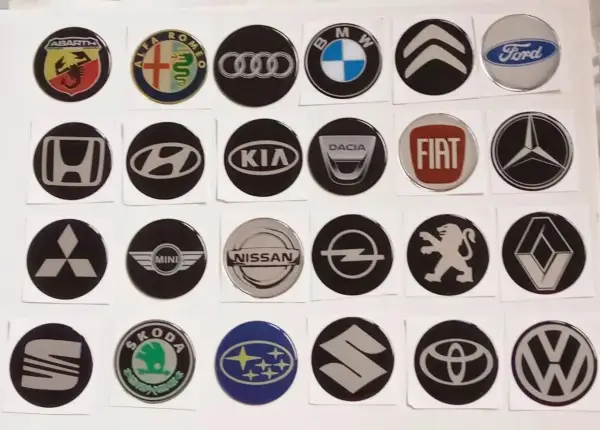 Kolekcja okrągłych znaków na samochodach: Abarth, Alfa Romeo, Audi, BMW, Citroen, Ford, Honda, Hyundai, Kia, Dacia, Fiat, Mercedes, Mitsubishi, Mini, Nissan, Opel, Peugeot, Renault, Seat, Skoda, Subaru, Suzuki, Toyota, Volkswagen.