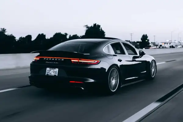 Czarny Porsche Panamera Turbo jedzie autostradą. Tablica rejestracyjna CVC-911. Limit 150 tys. VAT-26.