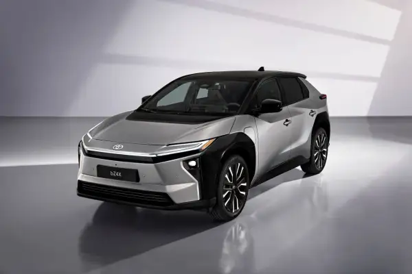 Srebrny Toyota bZ4X z czarnym dachem, gotowy na długie podróże. Ten elektryczny SUV oferuje imponujący zasięg.