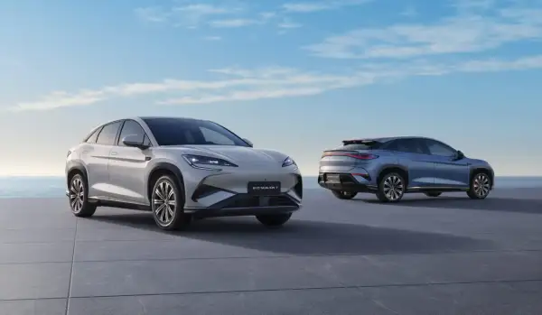 Dwa nowoczesne SUV-y marki BYD, jedne z wielu chińskich marek samochodów, prezentują się na tle błękitnego nieba i morza.