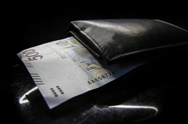 Czarny portfel z banknotem 500 zł. Zastanawiasz się nad opłatami dodatkowymi w leasingu a VAT?