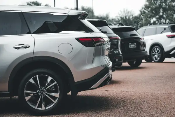 Rzędy lśniących SUV-ów, w tym srebrny model z silnikiem wolnossącym, czekają na swoich właścicieli.