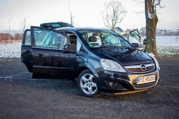 Czarny Opel Zafira B z otwartymi drzwiami, prezentujący różne wersje wyposażenia.