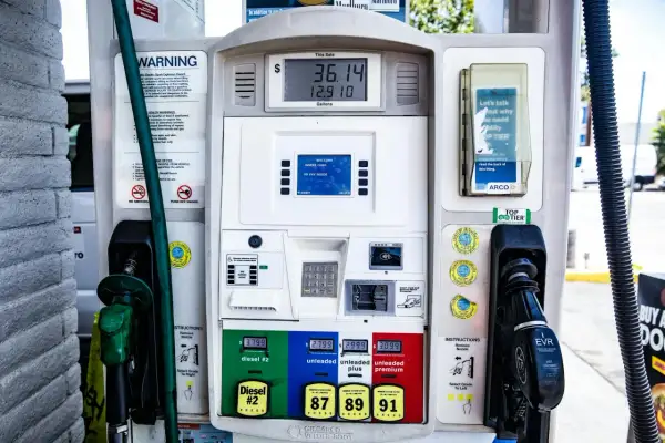 Stacja paliw z dystrybutorem, na którym widać cenę **diesel** do miasta, różne rodzaje paliwa i instrukcje.