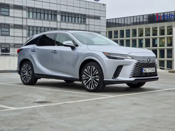 Eleganckie japońskie samochody, jak ten srebrny Lexus, prezentują się nowocześnie na tle biurowców.