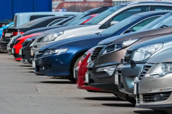 Rząd samochodów na parkingu. Zastanawiasz się, do jakiej kwoty można płacić gotówką za taki pojazd?