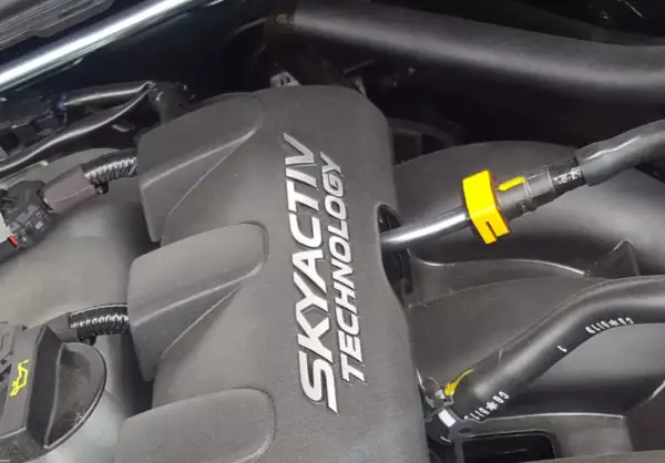 Silnik SKYACTIV TECHNOLOGY, serce oszczędnych silników benzynowych, z widocznymi przewodami i złączkami.