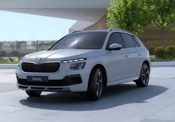 Jasnoszary SUV Skoda Kamiq z fabrycznym LPG prezentuje się nowocześnie na tle architektury i zieleni.